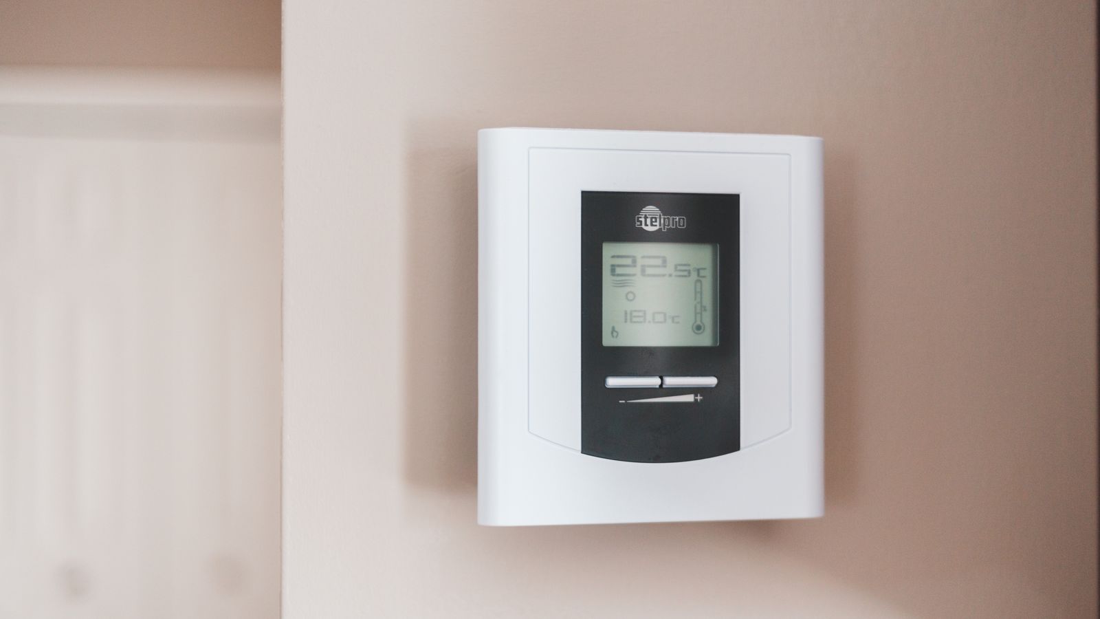 Termostato digital moderno montado en una pared, mostrando la temperatura en grados Celsius