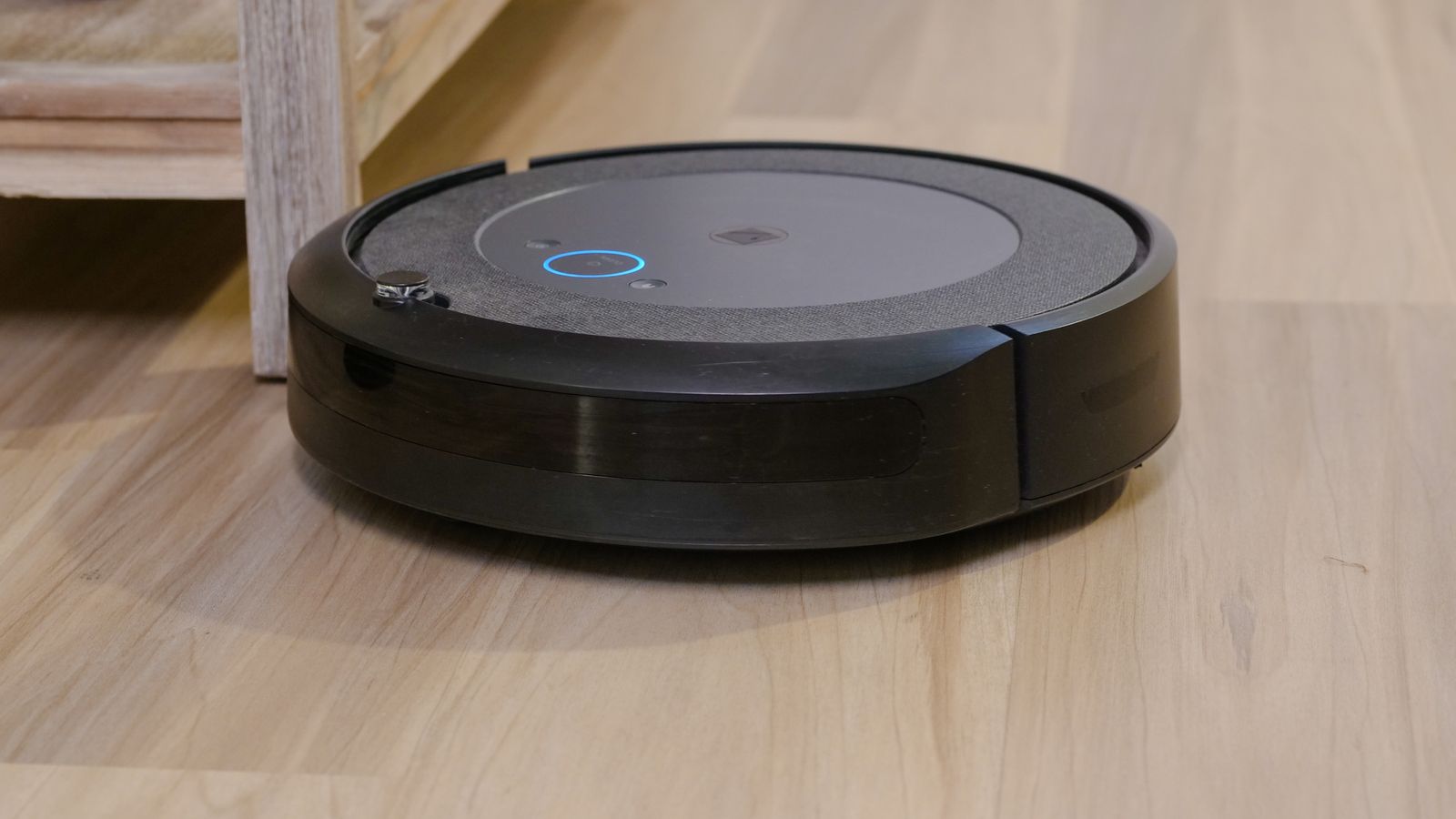 Robot aspirador navegando por un suelo de madera en un salón